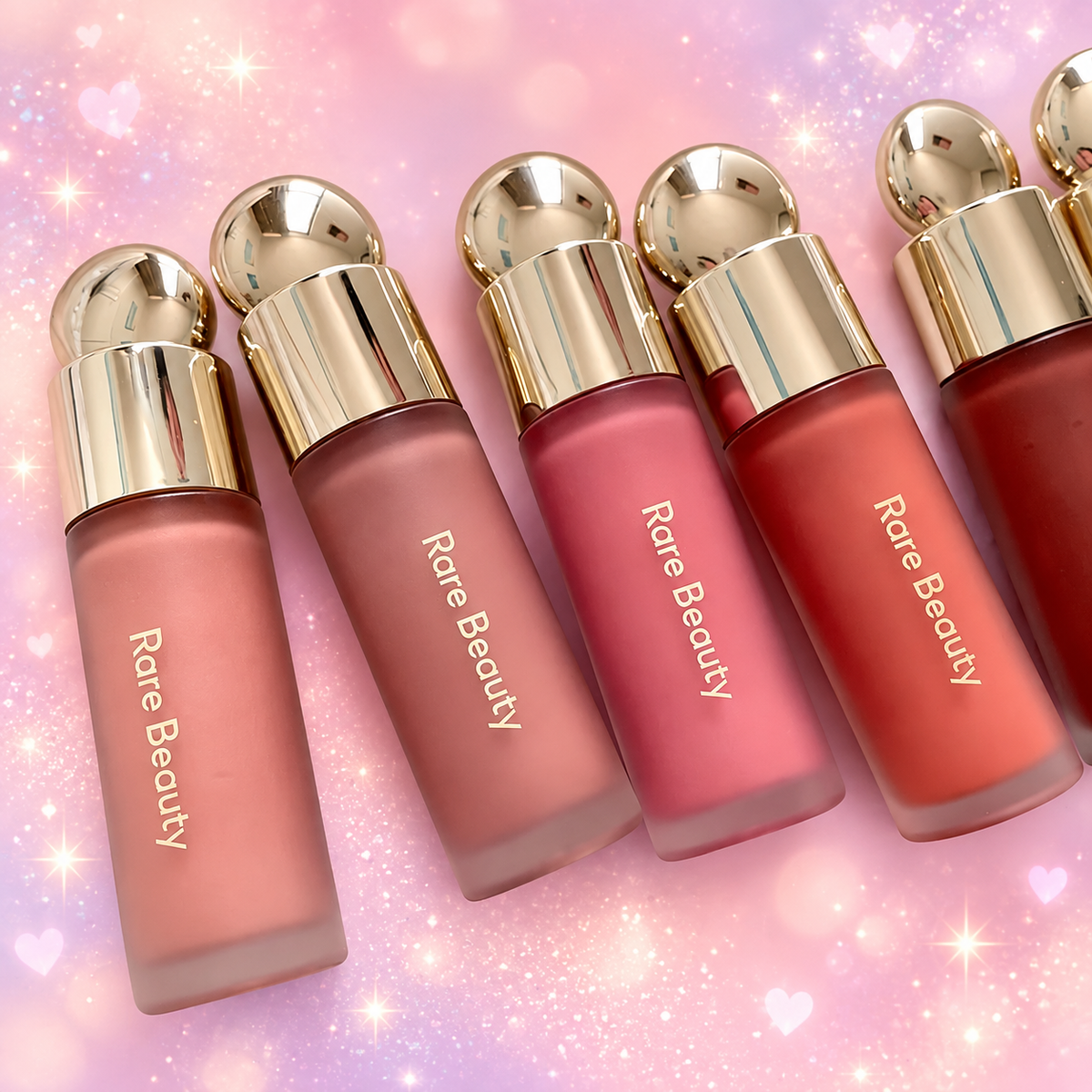 Rare Beauty Soft Pinch Liquid Blush bottles on a pink and lavender sparkle background