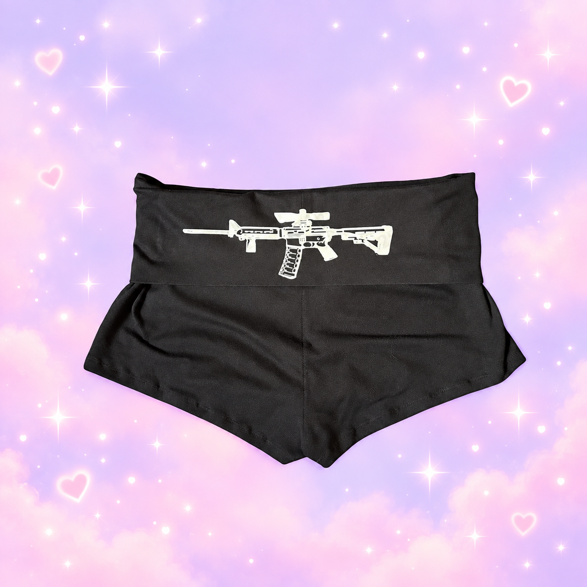 Black Y2K geometric print shorts on a pastel lavender and pink sparkling heart background